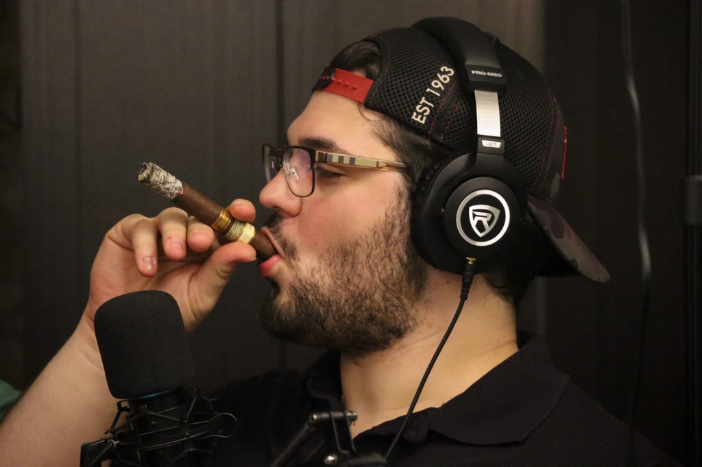 Zach smoking a cigar on the podcast